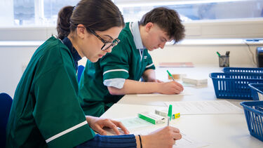 Two Pharmacy students writing at a desk