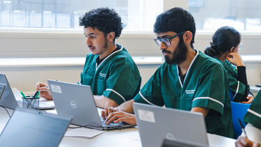 Two male Pharmacy students on laptops