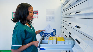 A female Pharmacy students sorts through medication at the dispensary