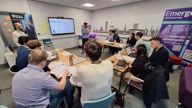 Group of students sat around tables in start-up Studio 