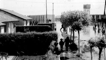 Grainy black and white photo of a flooded barrio