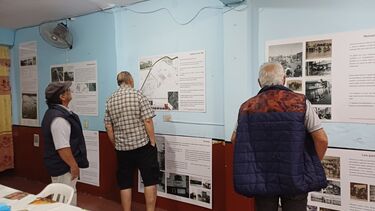 Three men look at photos in an exhibition