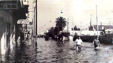 Two men wading through a flooded town