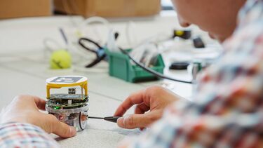 A person working on a robotic structure