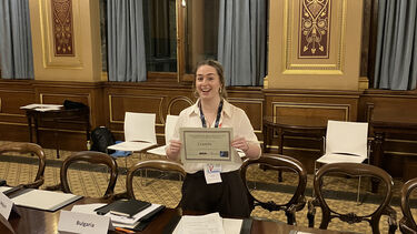 Student posing with award certificate