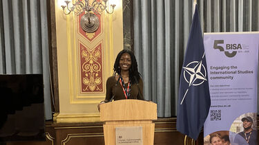Student posing at a podium 