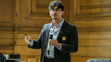 Student presenting on stage holding microphone