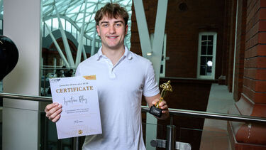 Man standing in the Heartspace with award and certificate smiling