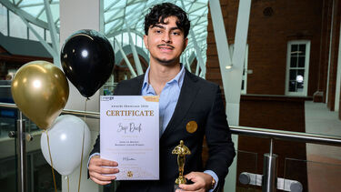 Man smiling at camera holding certificate in Heartspace
