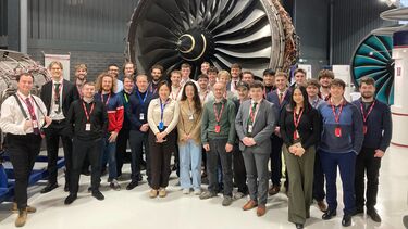 Aerospace students standing in front of an aero engine at Rolls-Royce