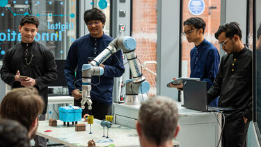 Students in the DIZ using the robot arm