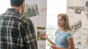 Student shows employer display of their work