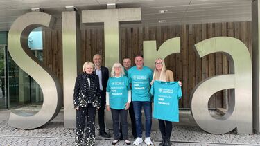 A group of people stand in front of the SITraN building