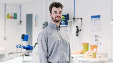 Jamie Sterland stood by a mock set up of a ward in Clinical Skills. 