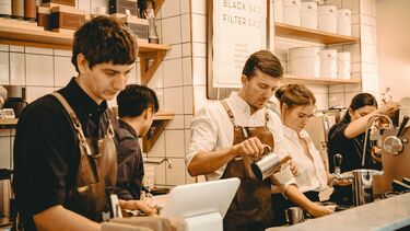 Young cafe workers preparing coffee 