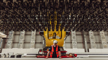 A researcher looking at equipment above them in the COMPASS facility