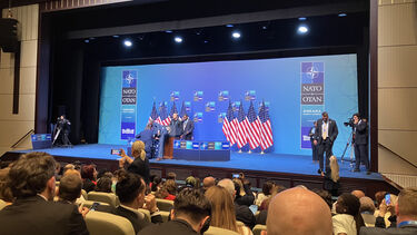 People setting up the stage for the US Press Conference during NATO 2026