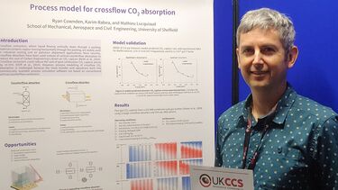 Engineer standing next to his research poster