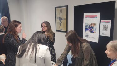 Staff talking to students at an information stand
