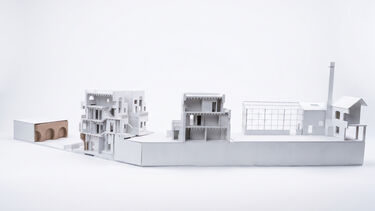A 3D model of some open buildings a factory behind a wall