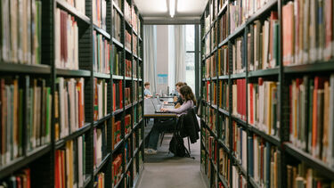 Students sitting at laptop in a library