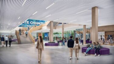 People walking through a large foyer of an open plan building with the words 'climate change' and 'biodiversity' printed on interior windows