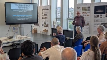 A group of people looking at a presenter and slideshow