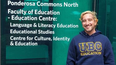 Antonios standing in front of a sign for the Ponderosa Commons North building at the University of British Colombia
