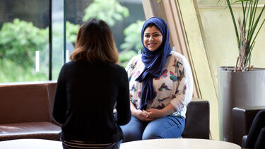 Two female students in a University building, one wears a headscarf