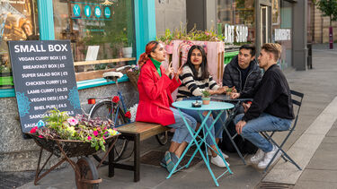 a group of student sitting and talking at a cafe