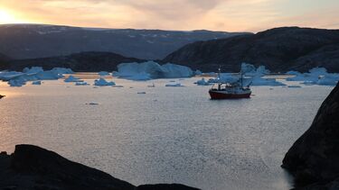 A boat on water between ice caps in a fjord