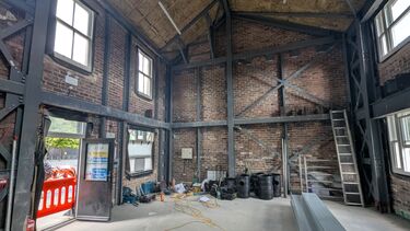 Inside of Henderson's House showing no fixtures and fittings.  Metal frame structure and brickwork.  Double height building with no first floor.