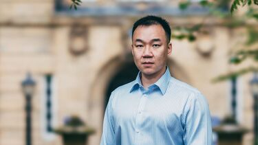 Yufeng Lai stands in front of a University building