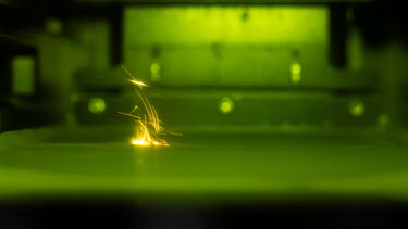 Sparks within a chamber of a laser powder bed fusion additive manufacturing 3D printer