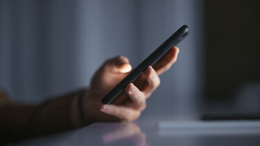 A hand holding a mobile phone 