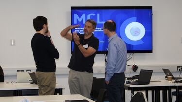 Three engineers engaging in conversation