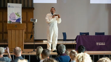 Man in spacesuit on stage in front of audience