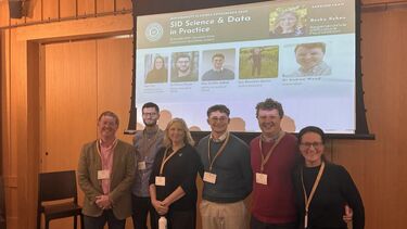Group of people standing in front of a presentation screen