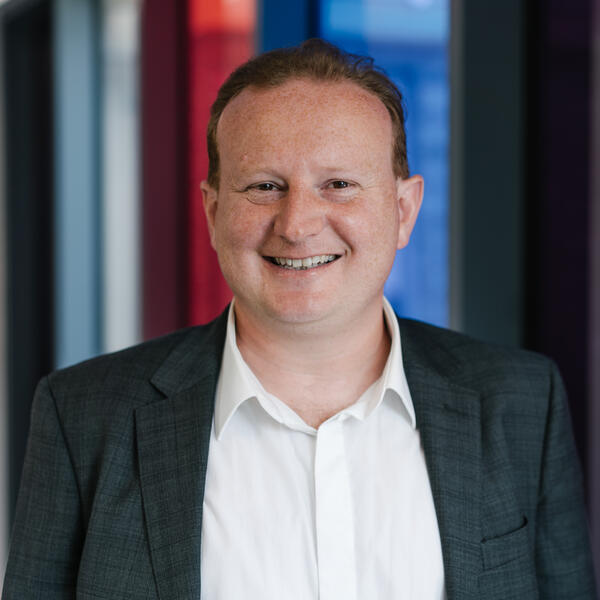 Profile picture of David Littlewood wearing a white shirt and dark grey jacket.