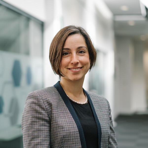 Profile picture of Merve Keskin wearing a black top and a grey checked jacket.