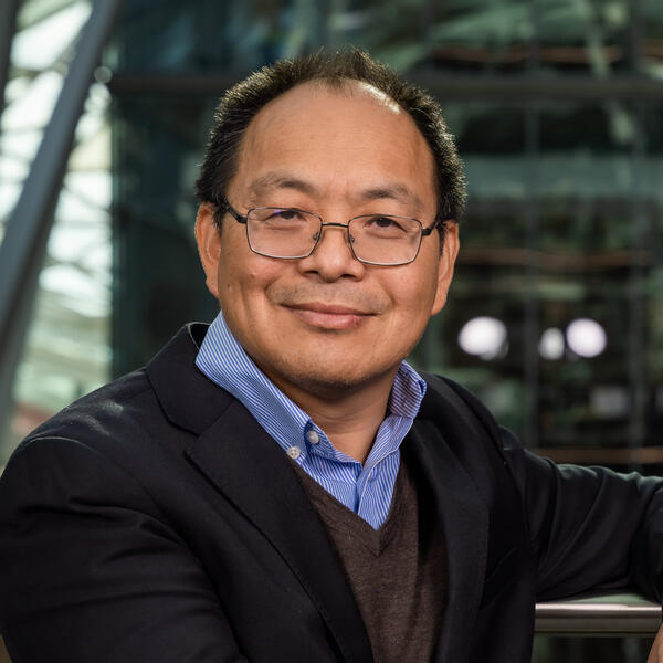 Profile picture of Professor Meihong Wang smiles as he stands in the Engineering Heartspace