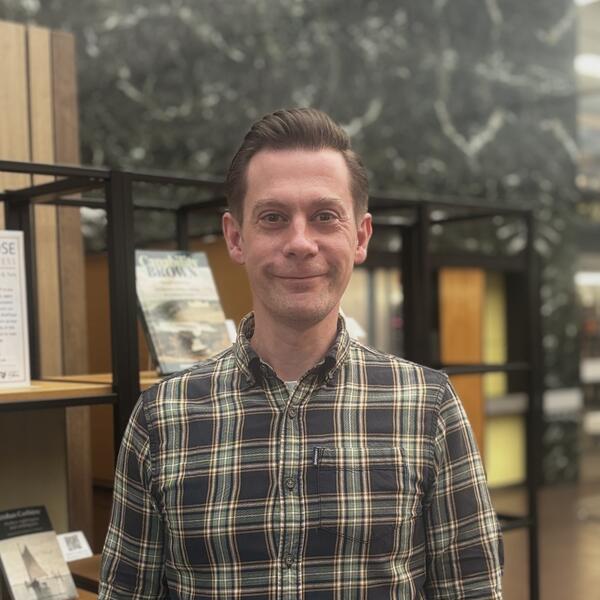 Profile picture of Oliver stands in the catalogue hall in Western Bank Library 