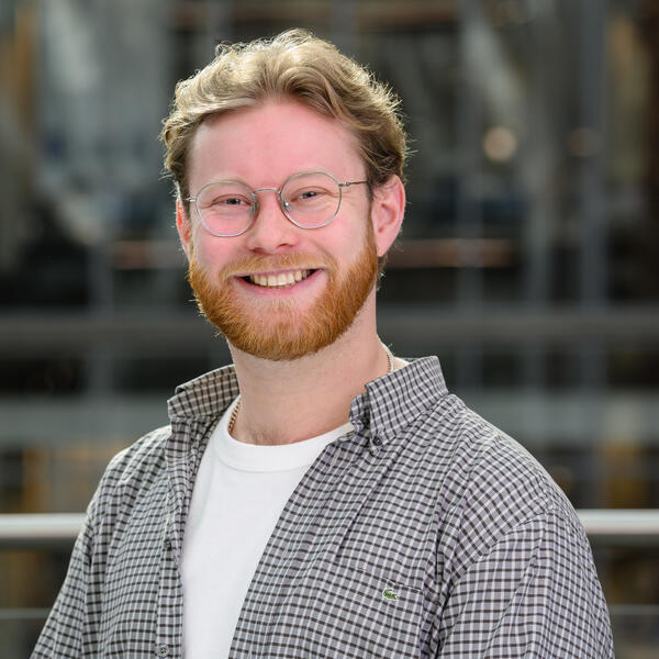 Profile picture of Portrait of a researcher smiling and wearing a checked shirt and glasses