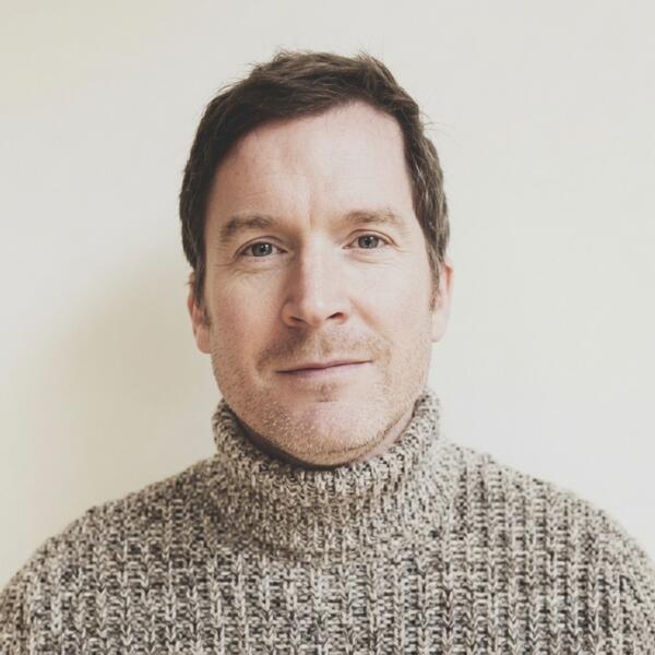 Profile picture of Neil Boyle looks directly to camera, wearing a rollneck jumper against a neutral backdrop