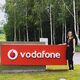 Laura Craciun, computer science alumni standing by a Vodafone sign