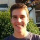Daniel standing in front of a house, in the sun