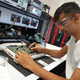 Photo showing student Rishi soldering a circuit board in the Electronics lab in the Diamond.