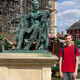 Postgraduate student Lewis beside a statue