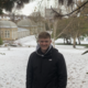 A man standing in the snow, framed by tree branches