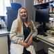 A PhD student in a lab coat in front of lab equipment